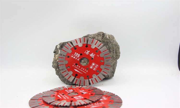 Red diamond blade displayed against a rough concrete piece