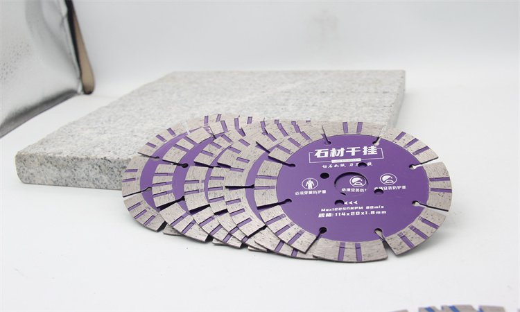 Purple patterned-rim diamond blades beside a stone slab