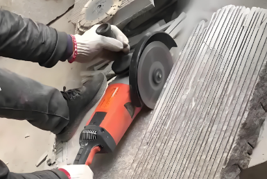 Handheld grinder cutting parallel grooves in a stone slab