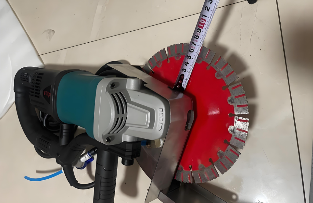 Red blade mounted on a handheld tool beside a measuring tape